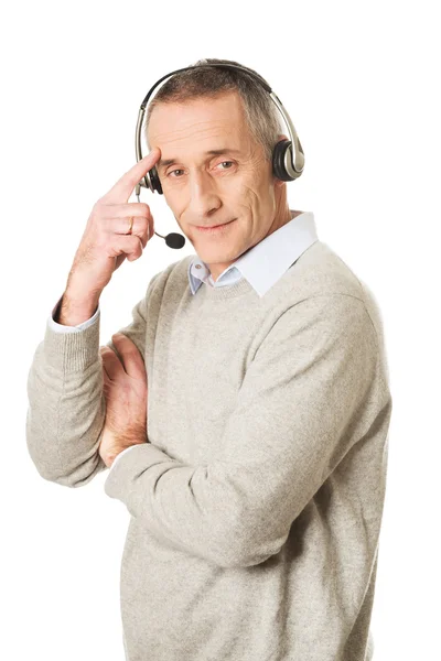 Call center man wearing a headset touching head — Stock Photo, Image