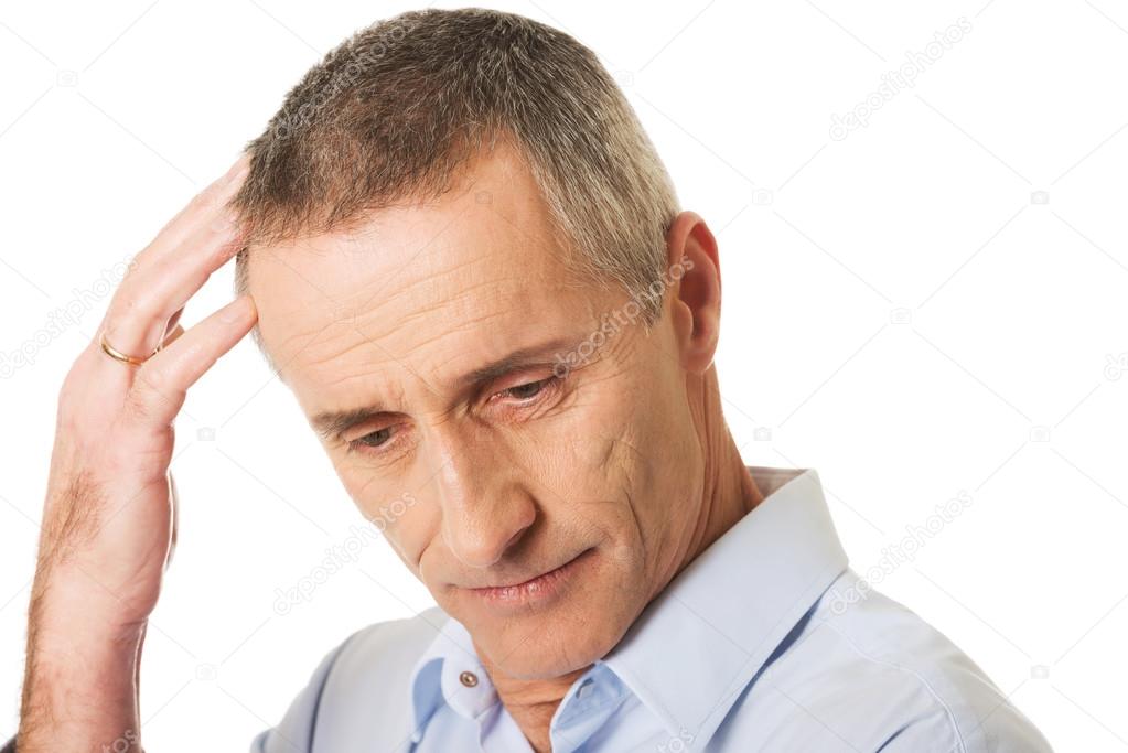 Portrait of confused man scratching his head