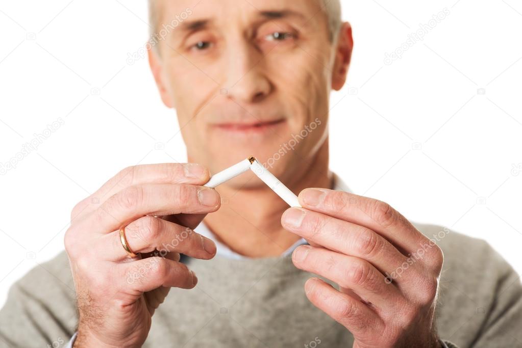 Portrait of mature man breaking cigarette