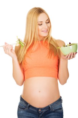 Hamile kadın salata yiyor.