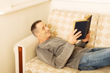 Olgun adam evde kitap okurken