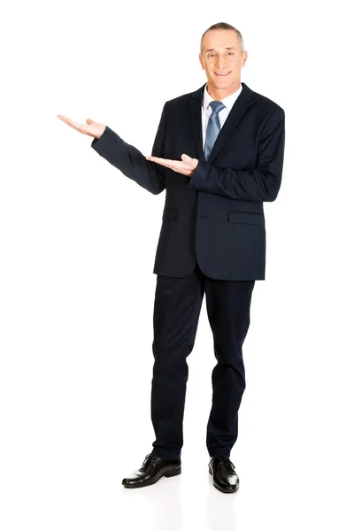 Full length businessman with welcome gesture — Stock Photo, Image