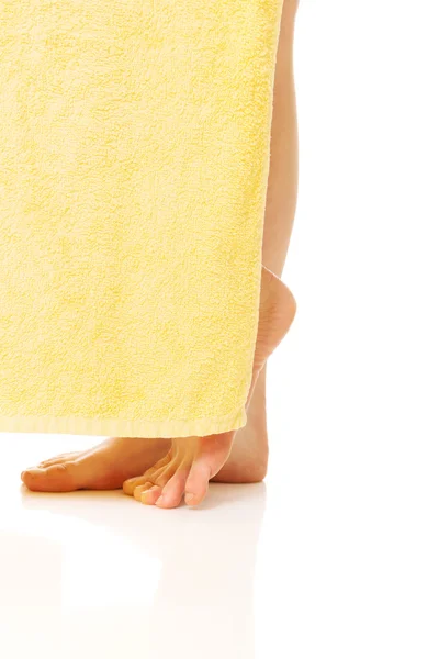 Elegantes piernas femeninas cubiertas con una toalla amarilla —  Fotos de Stock