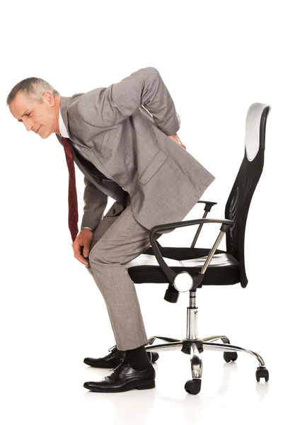 Бизнесмен с болью в спине встает со стула — стоковое фото