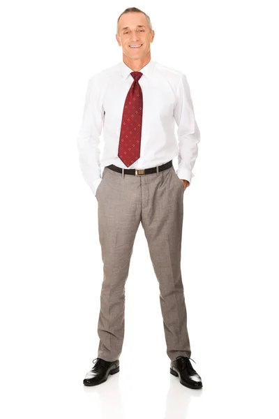Full längd affärsman med händerna i fickorna — Stockfoto