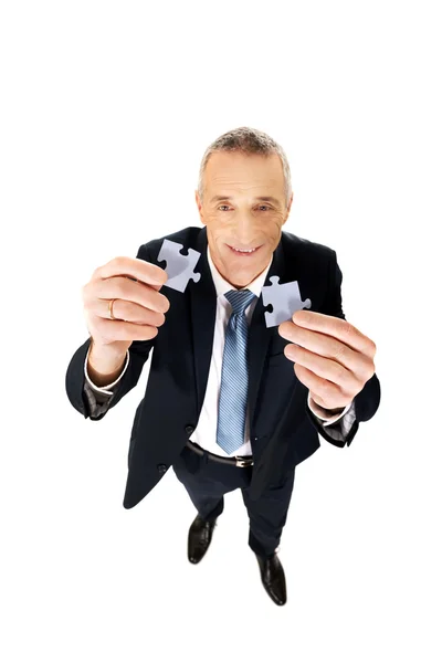 Geschäftsmann versucht Puzzleteile zu verbinden. — Stockfoto