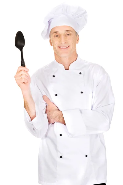 Koch hält schwarzen Plastiklöffel in der Hand — Stockfoto
