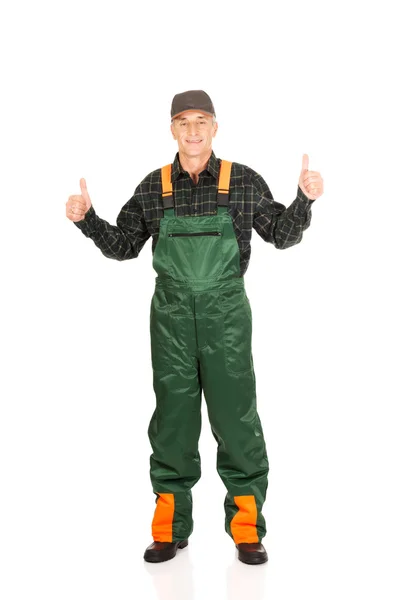 Volwassen tuinman in uniform met Duimschroef opwaarts — Stockfoto