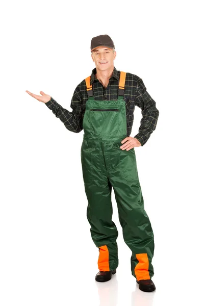 Gardener in uniform showing space on the left — Stock Photo, Image