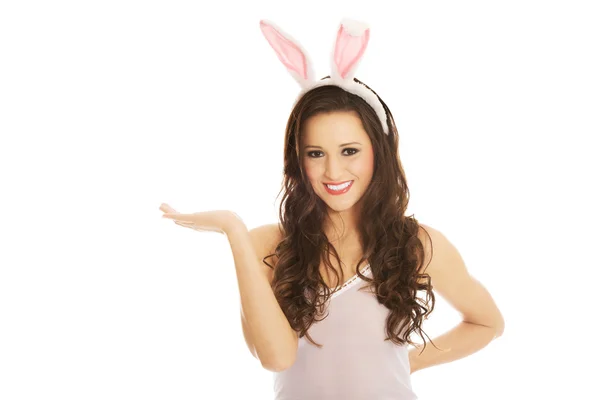 Woman wearing bunny ears and presenting a copyspace — Stock Photo, Image