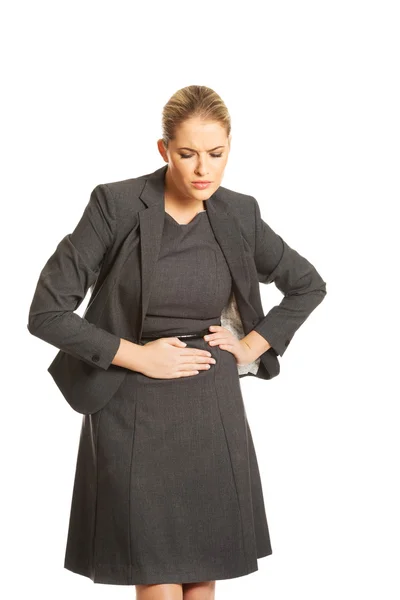 Blonde businesswoman with strong stomachache — Stock Photo, Image