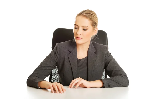 Улыбающаяся деловая женщина сидит за столом — стоковое фото