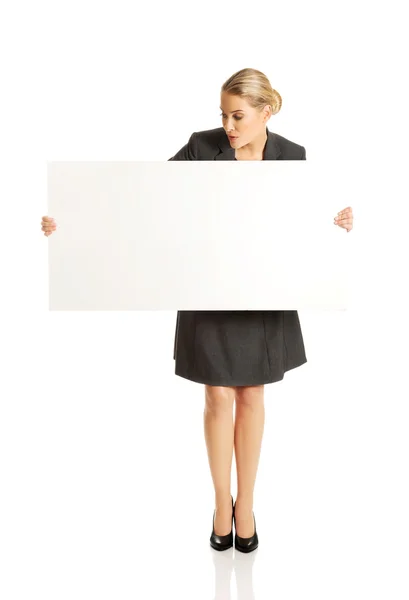Businesswoman holding empty billboard — Stock Photo, Image