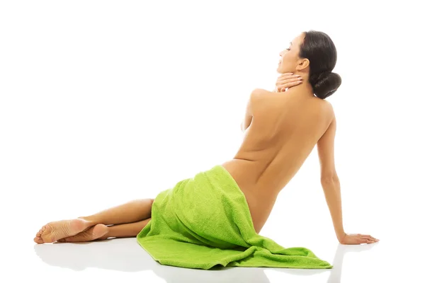 Donna vista posteriore seduto avvolto in asciugamano — Foto Stock