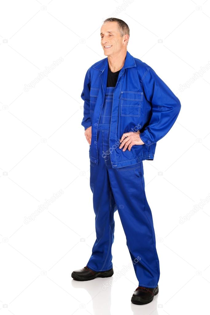Full length smiling repairman with hands on hips