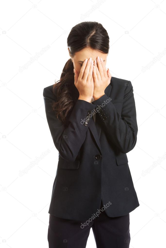 Businesswoman covering her face because of shame