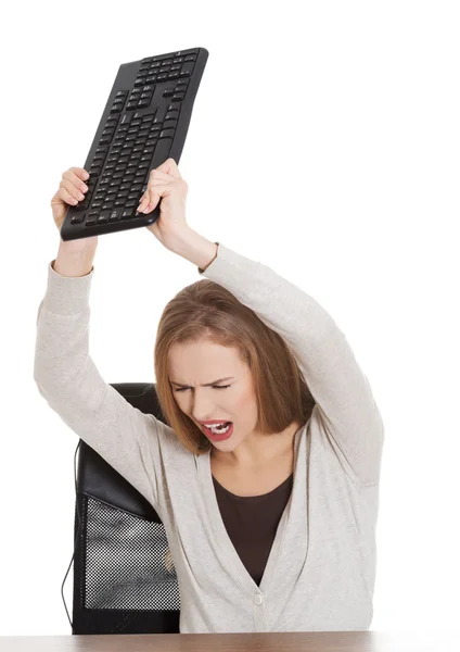 Angry woman throwing a pc keyboard — Stock Photo, Image