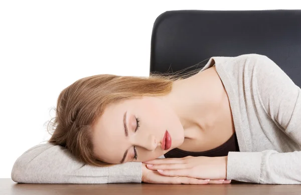 Уставшая женщина спит на столе — стоковое фото