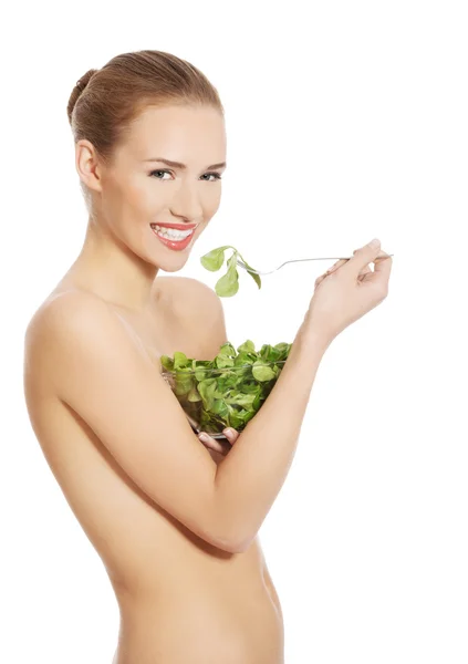 Vista lateral de la mujer desnuda comiendo lechuga del tazón —  Fotos de Stock