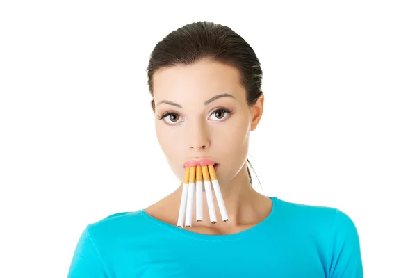 Ung kvinna med grupp av cigaretter i mun — Stockfoto