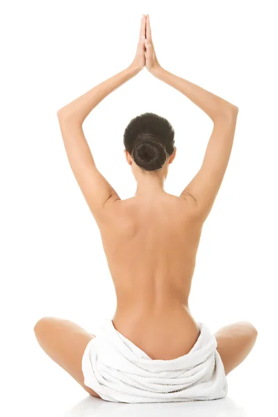 Visão traseira de uma mulher em toalha praticando ioga — Fotografia de Stock