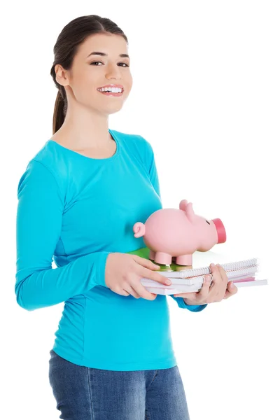 Happy woman standing with piggybank and notebooks — Stock Photo, Image