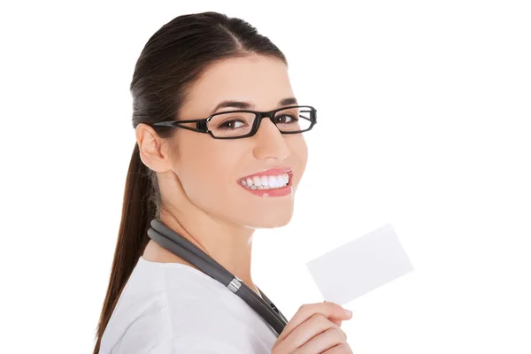 Retrato de médico fêmea segurando cartão branco — Fotografia de Stock