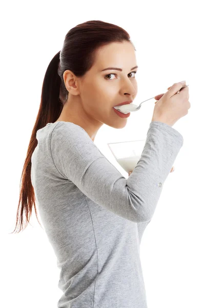 Vista laterale di donna sana mangiare yogurt naturale — Foto Stock