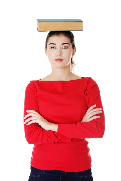 Worried young woman holding book on her head — Stock Photo, Image