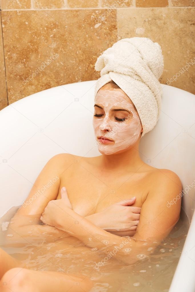 Woman relaxing in bath with face mask