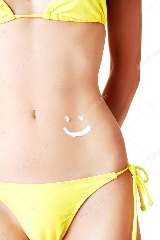 Sunscreen lotion over female slim belly