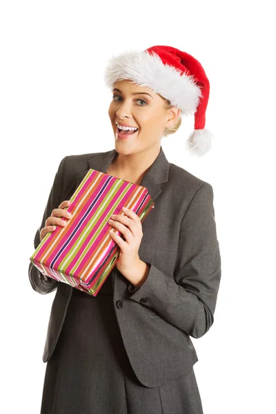 Woman weating Santa hat and holding a present — Stock Photo, Image