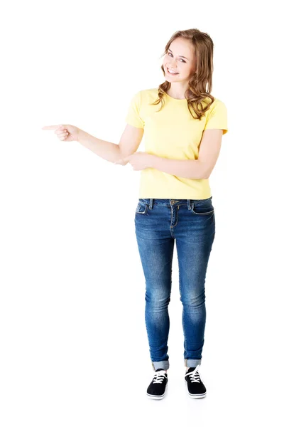 Ung kvinna pekar mot tomt utrymme — Stockfoto