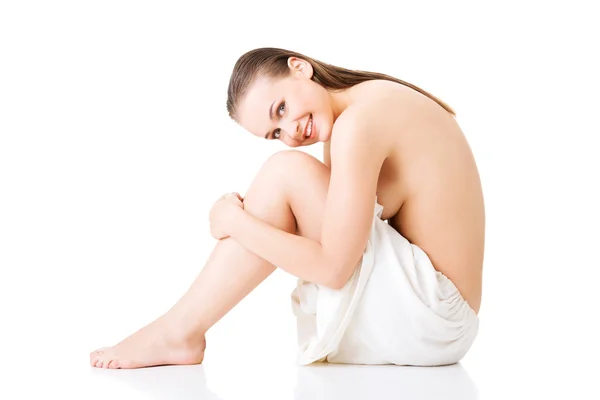 Side view of nude woman wrapped in towel sitting — Stock Photo, Image