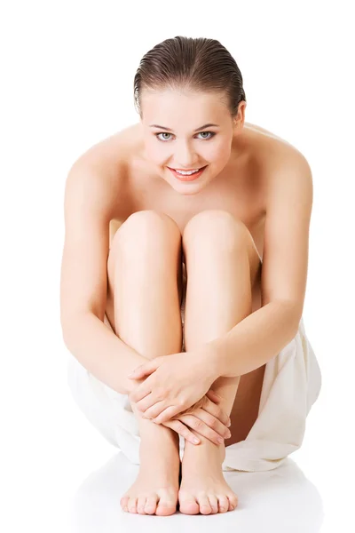 Front view of nude woman wrapped in towel sitting — Stock Photo, Image