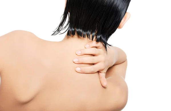 Rückseite nackte Frau, die ihren Nacken berührt — Stockfoto