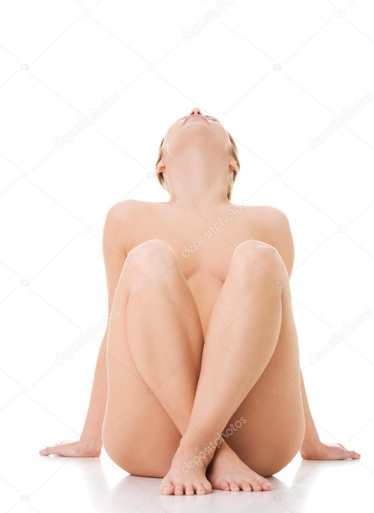 Front view of nude female sitting and looking up