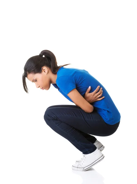 一个女人与胃痛跪的侧视图 — 图库照片