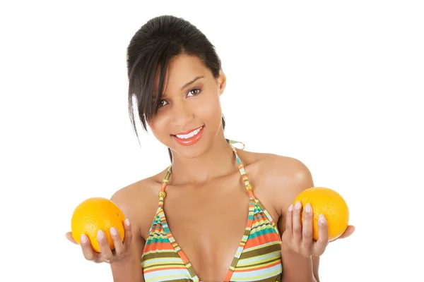 Szczęśliwa kobieta w strój kąpielowy gospodarstwa pomarańcze — Zdjęcie stockowe