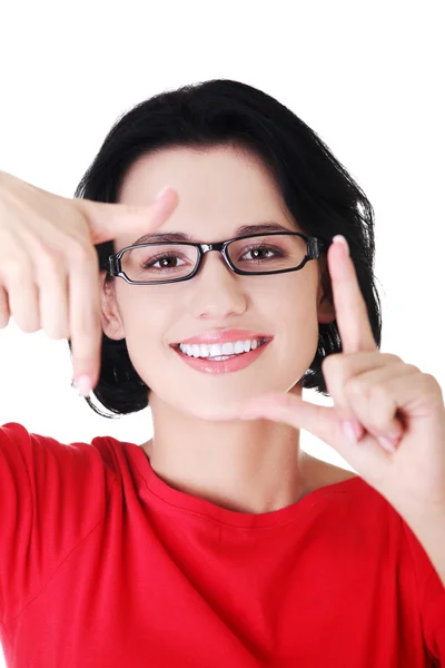 Mulher feliz criando moldura com dedos — Fotografia de Stock