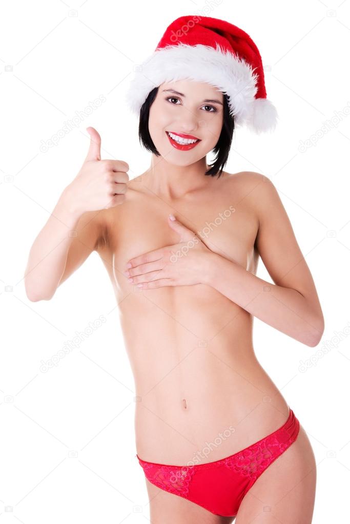 Nude woman wearing santa hat showing thumbs up