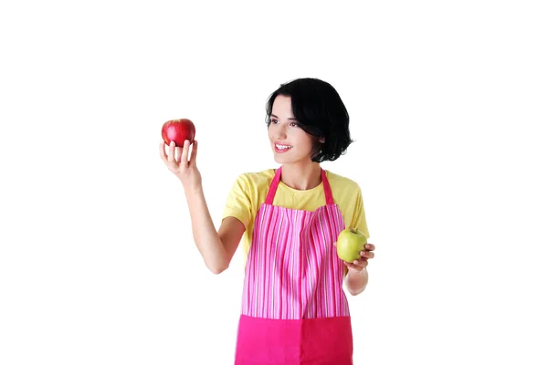 Woman in kitchen apron holding apples — Stock Photo, Image