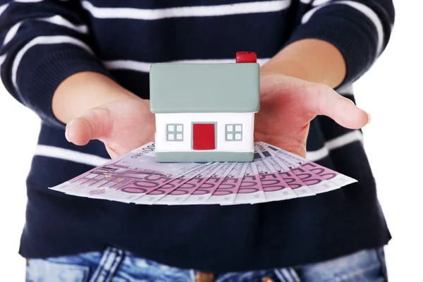 Woman holding a house model and euro bills — Stock Photo, Image