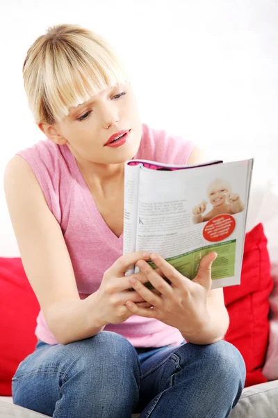 Mooie blonde vrouw die een krant lezen — Stockfoto