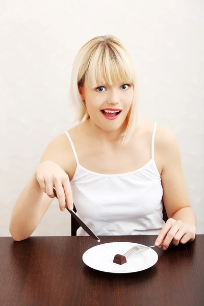 Mooie vrouw eten een stuk van chocolade — Stockfoto