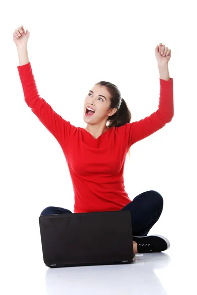 Mujer alegre sentado con las piernas cruzadas con el ordenador portátil — Foto de Stock