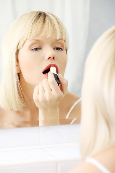 Joven hermosa mujer haciendo maquillaje cerca del espejo —  Fotos de Stock