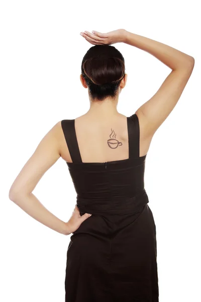 Bakifrån av en kvinna i klänning med kaffe tatuering — Stockfoto