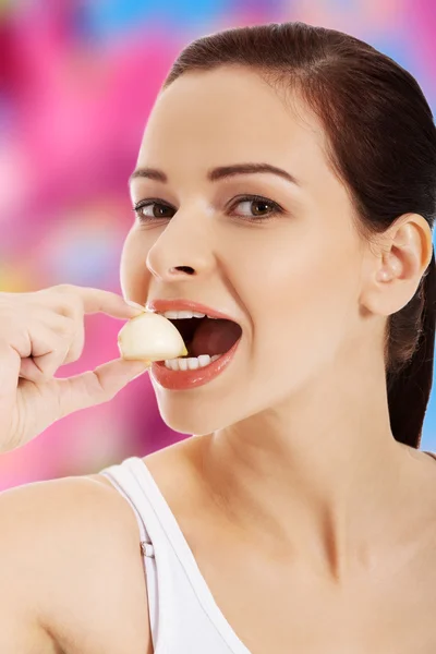 Mujer joven comiendo ajo — Foto de Stock