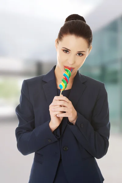 Hermosa mujer de negocios comiendo piruleta —  Fotos de Stock